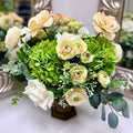 Signature Palais Bowl Duchess permanent floral arrangement with green hydrangeas, ivory and cream blooms in a Warm Bronze vessel.