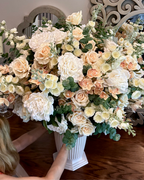 Grand Palais floral arrangement in the Bone White finish, Premium size, Peaches & Cream palette, featuring lifelike cream roses, peach cymbidium orchids, white peonies, blossom stems, and eucalyptus.