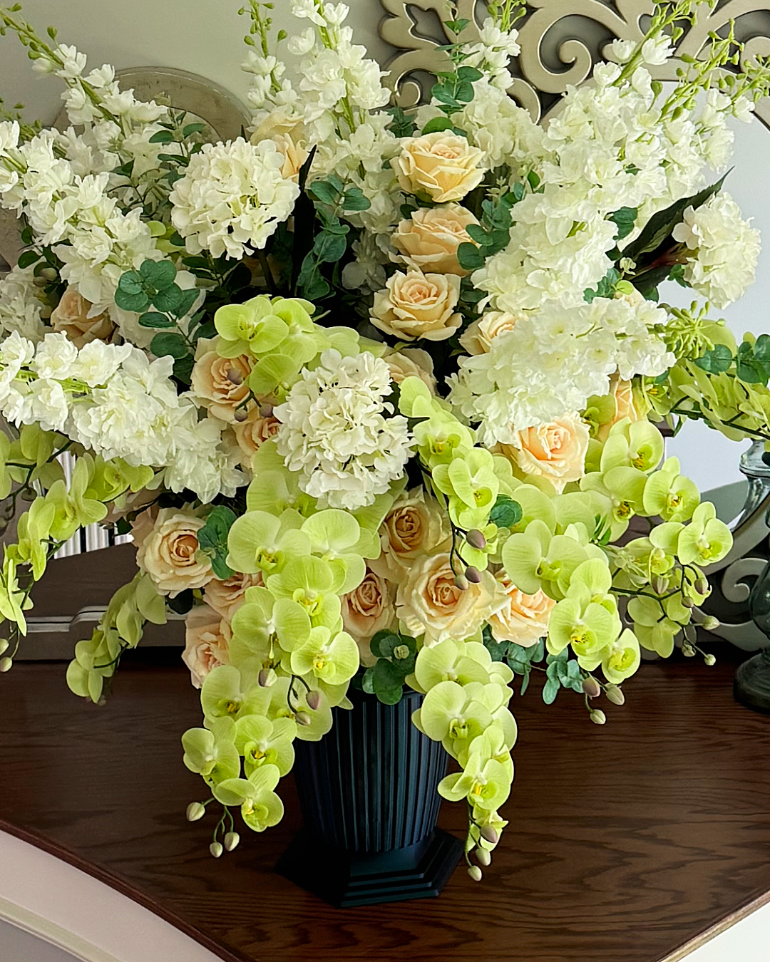 Grand Palais Premium permanent floral arrangement in the Pistachio Garden palette featuring cascading green orchids, ivory hydrangeas, champagne roses, eucalyptus, and the Onyx Shimmer Grand Palais Bowl.