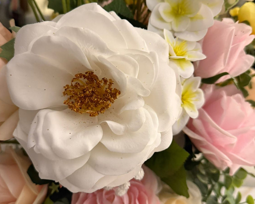 Bouquet of flowers including white, pink, and yellow roses.