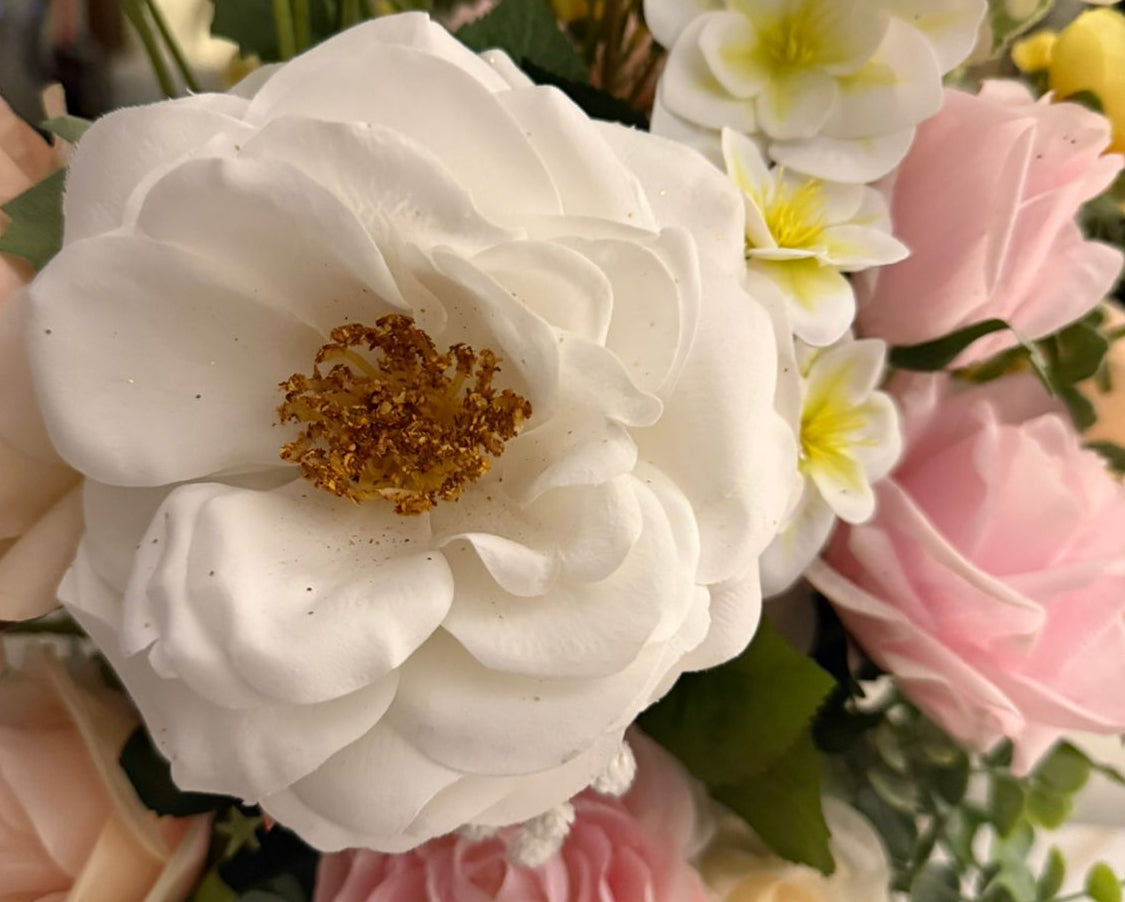 Bouquet of flowers including white, pink, and yellow roses.