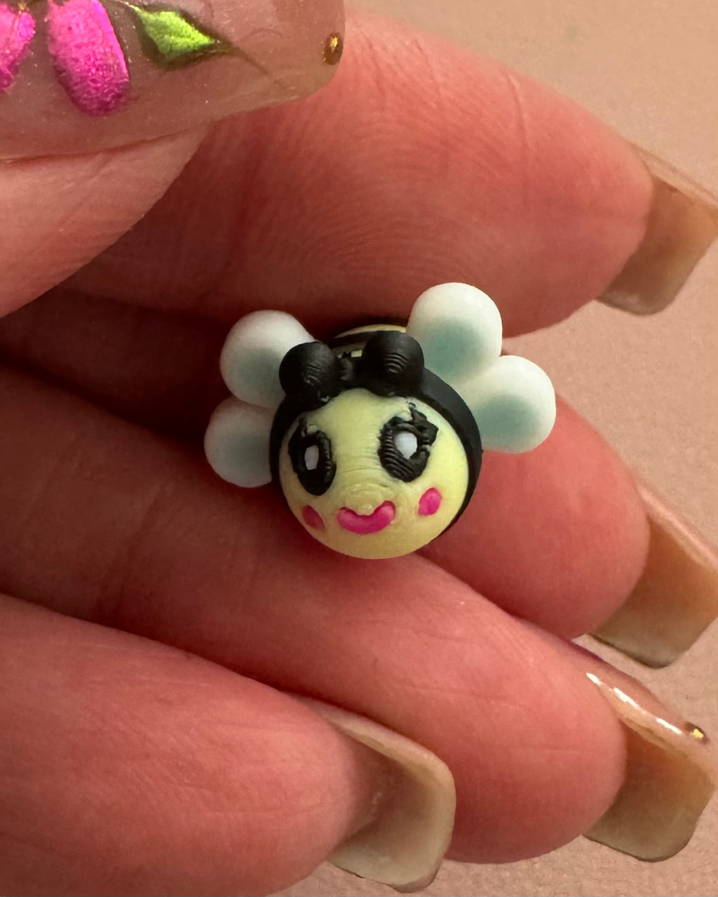 Front close-up of Bee Happy dangle earring featuring an artist-designed bee charm with white wings, hand-painted details, and sterling silver hook.