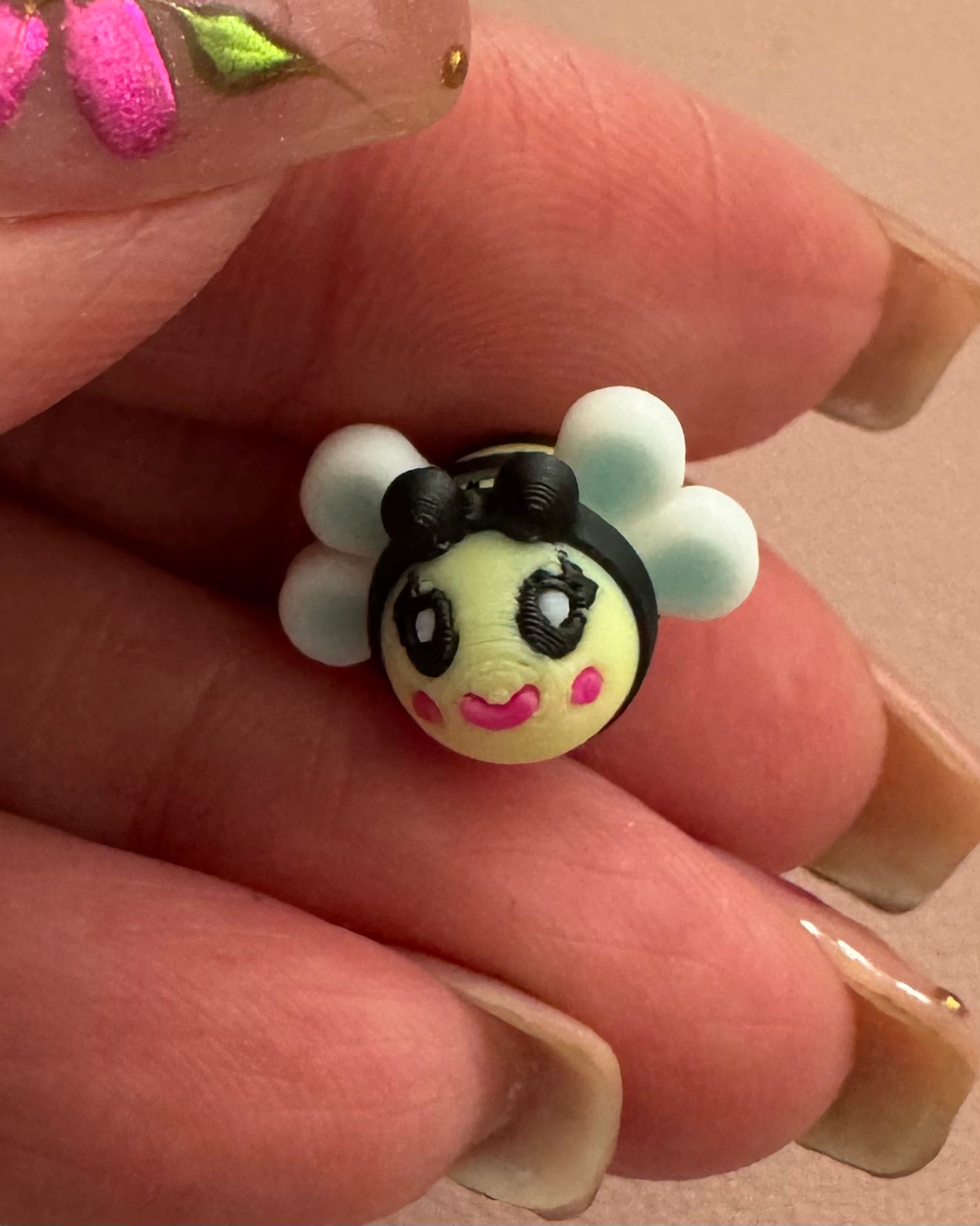 Front close-up of Bee Happy dangle earring featuring an artist-designed bee charm with white wings, hand-painted details, and sterling silver hook.
