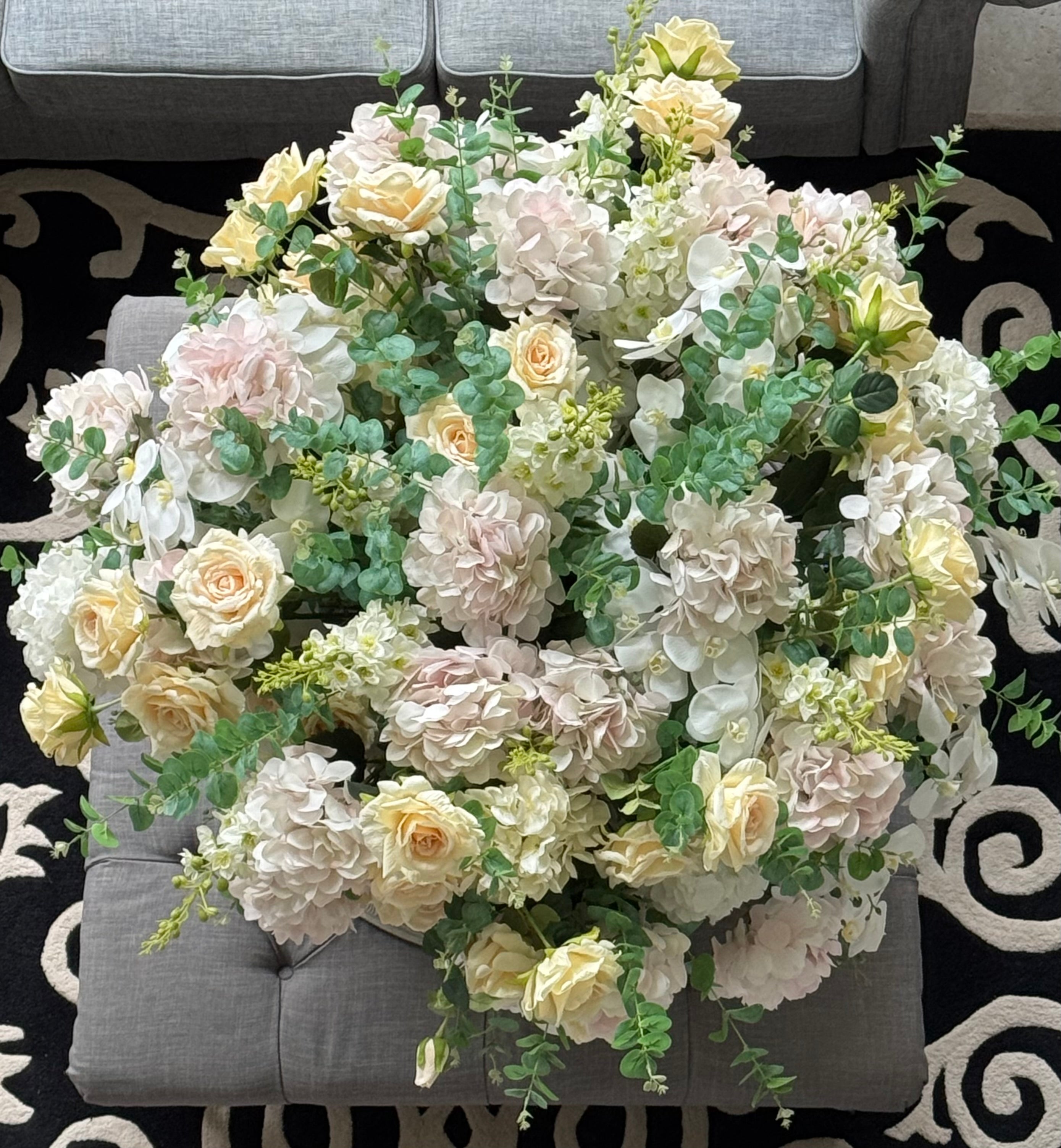 Overhead view of a Grand Palais Platinum luxury permanent floral arrangement featuring blush hydrangeas, ivory roses, white orchids, eucalyptus greenery, and premium blooms