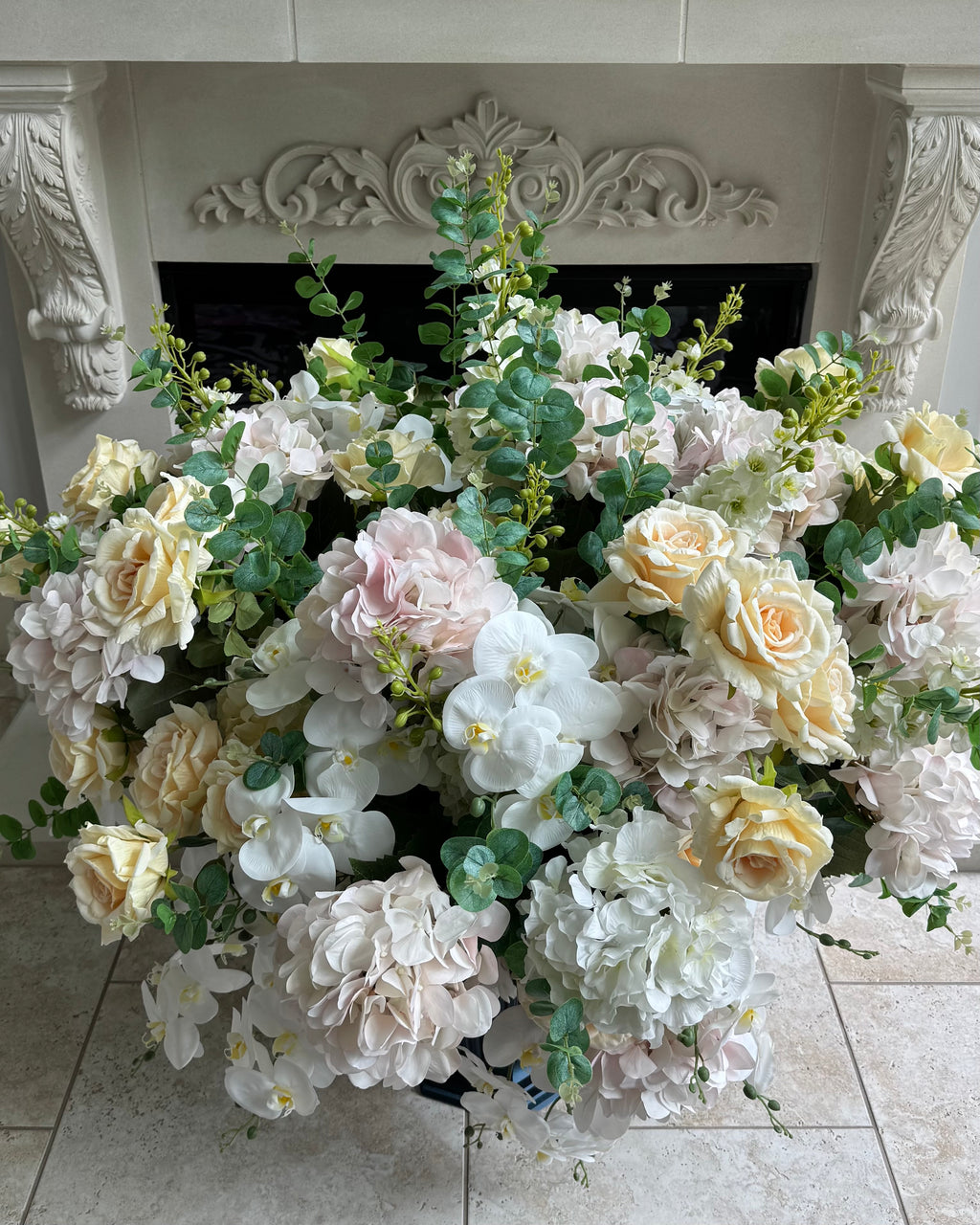 Grand Palais Platinum luxury permanent floral arrangement with blush hydrangeas, ivory roses, white orchids, and eucalyptus greenery displayed in an elegant interior setting