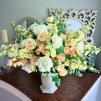 Grand Palais Premium permanent floral arrangement in the Peaches & Cream palette featuring cream peonies, blush roses, peach cymbidium orchids, flowering stems, and eucalyptus in a Bone White Grand Palais Bowl.