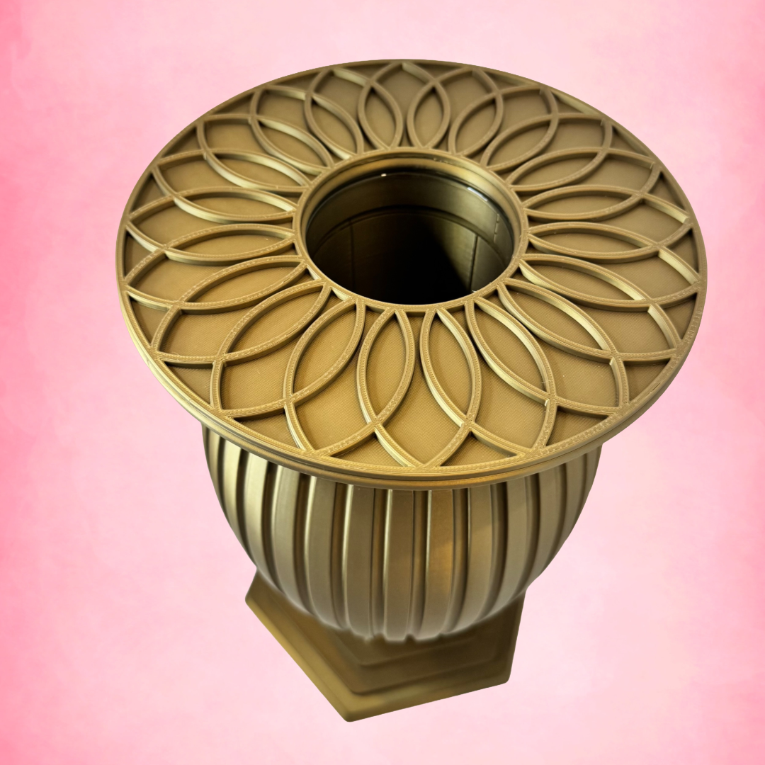 Decorative gold urn with intricate design on a pink background