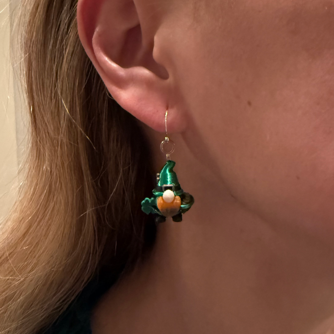 Close-up of a person wearing a green elf-shaped earring.