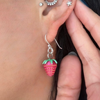 Lightweight strawberry earrings worn on ear, showing scale and everyday styling.