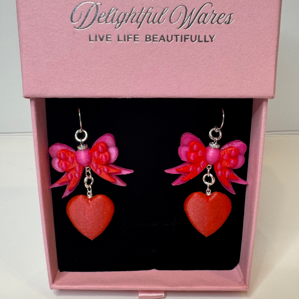 Bow & Heart Dangle Earrings presented in our Signature gift-ready jewelry box, featuring layered pink bows, red heart charms, and genuine 925 sterling silver hooks.