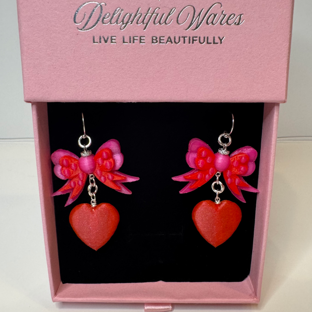Bow & Heart Dangle Earrings presented in our Signature gift-ready jewelry box, featuring layered pink bows, red heart charms, and genuine 925 sterling silver hooks.