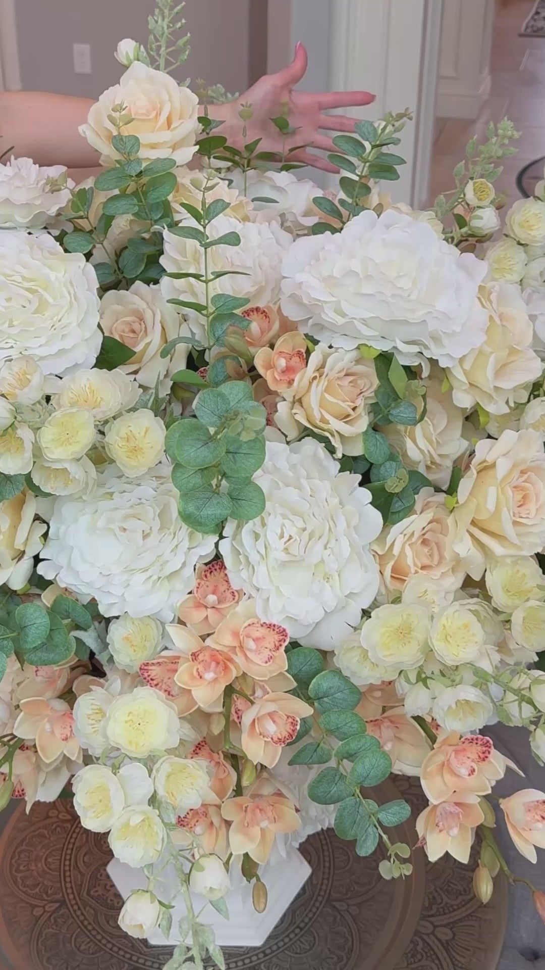 Close-up video of the Grand Palais Premium permanent floral arrangement in the Peaches & Cream palette, featuring lifelike ivory, cream, and soft peach blooms with eucalyptus in the Bone White Grand Palais Bowl.